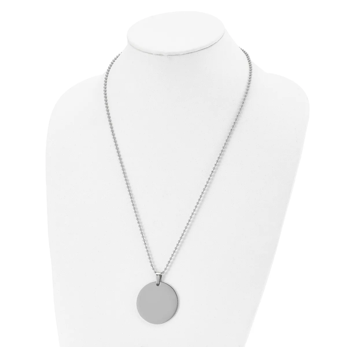 A silver-toned chain necklace with a plain circular pendant displayed on a white bust form.