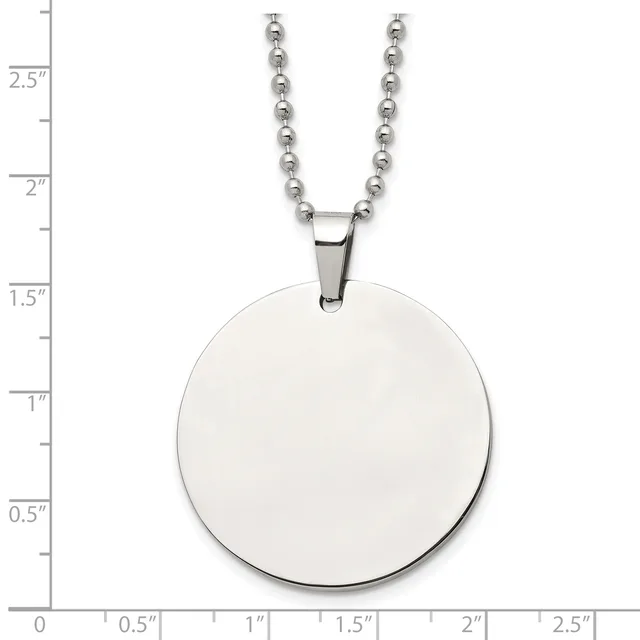 A polished silver circular pendant hangs from a silver ball chain necklace, displayed against a measurement scale showing the pendant is approximately one inch in diameter.