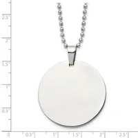 A polished silver circular pendant hangs from a silver ball chain necklace, displayed against a measurement scale showing the pendant is approximately one inch in diameter.