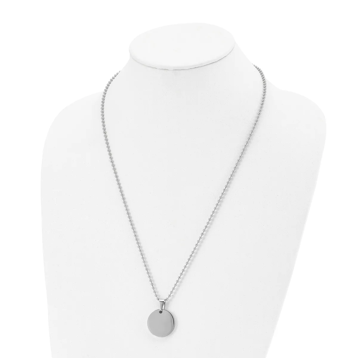 A silver-toned necklace with a thin chain and small circular pendant displayed on a white mannequin bust.