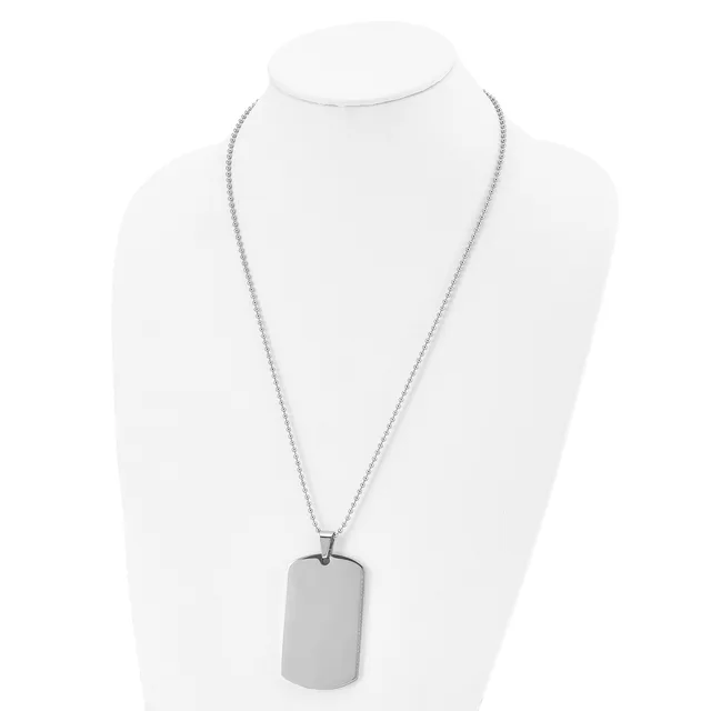 A silver-toned stainless steel dog tag pendant hangs from a matching box chain necklace, displayed on a white bust form.