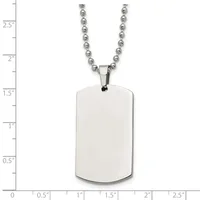 A polished stainless steel dog tag pendant with rounded corners hangs from a beaded chain, shown against a measurement scale indicating approximately 1.25 inches in height.