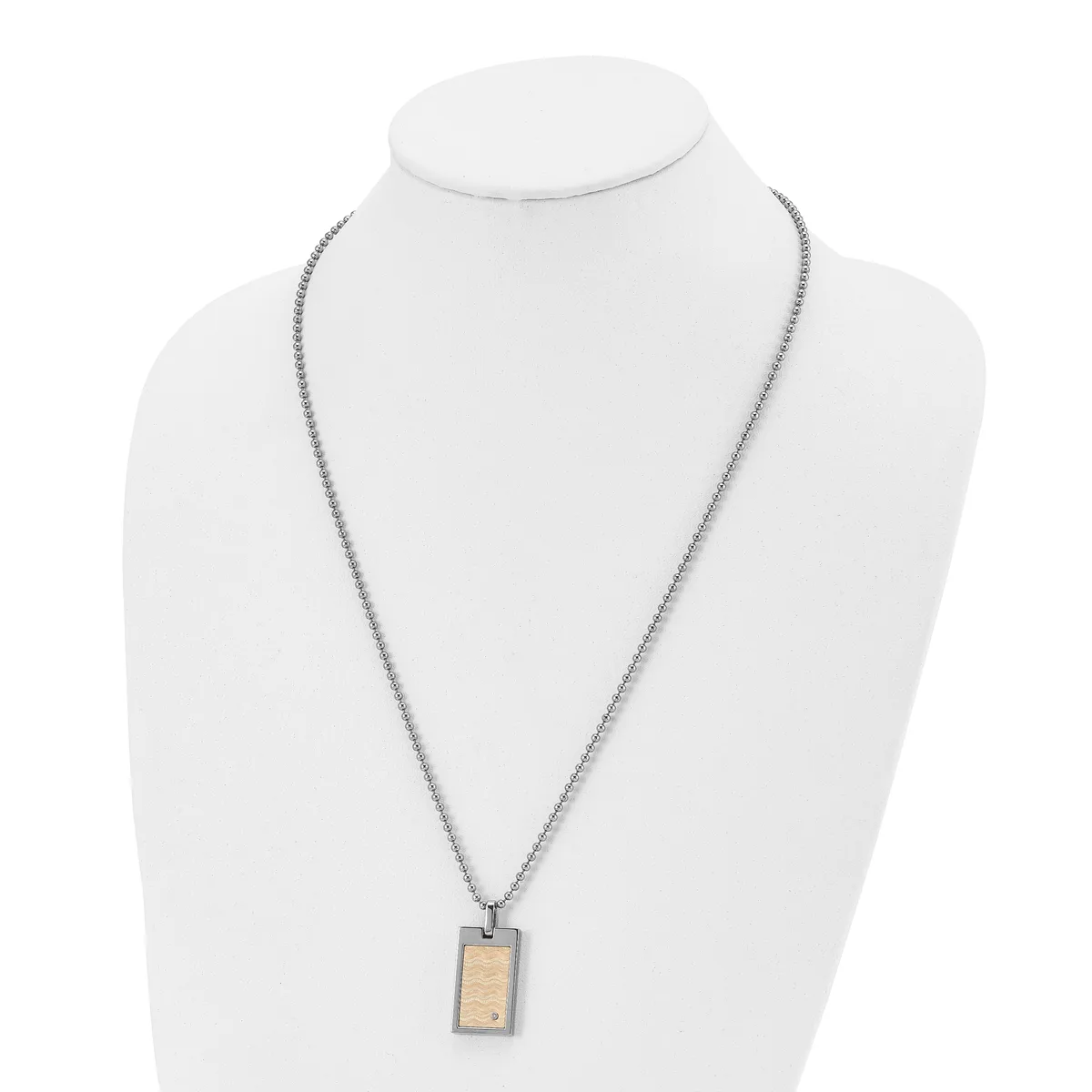 A stainless steel chain necklace with a small rectangular pendant featuring a wood inlay, displayed on a white bust form.