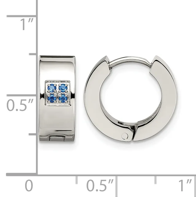 Polished silver huggie hoop earrings with four small blue gemstones set in a square pattern on the front, shown next to a ruler for scale.