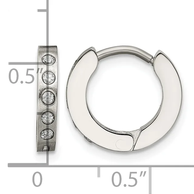 A pair of polished silver huggie hoop earrings with textured rectangular posts set with small round stones, shown next to a ruler for scale.