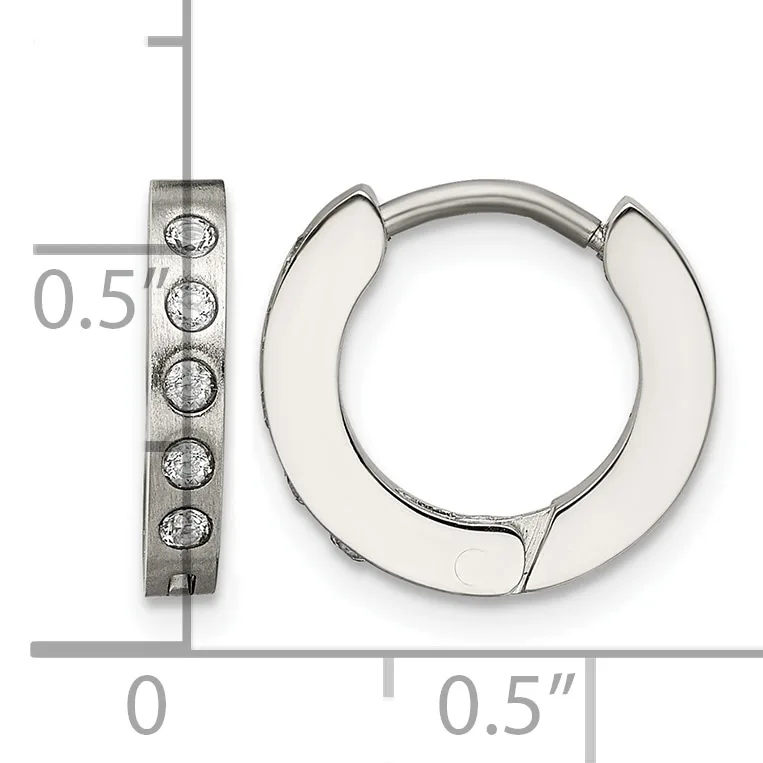 A pair of polished silver huggie hoop earrings with textured rectangular posts set with small round stones, shown next to a ruler for scale.