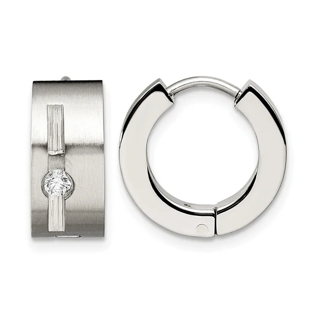 Two silver hoop earrings displayed against a white background: one wide polished hoop with a geometric cutout design, and one rectangular brushed silver earring with vertical grooves and a centered round crystal.