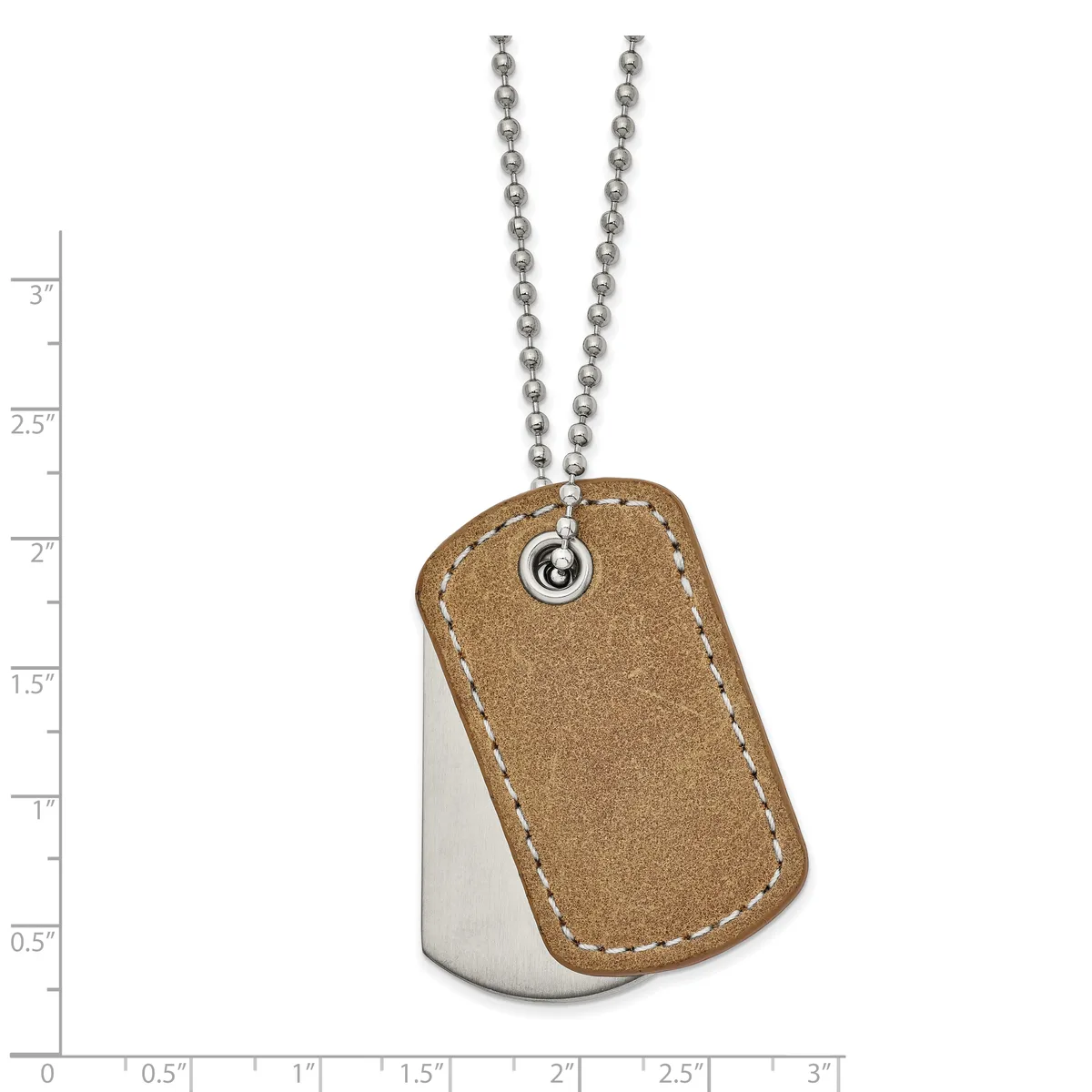 Dog tag pendant with tan suede leather front and polished steel back, suspended from a beaded chain, shown against a measurement scale.
