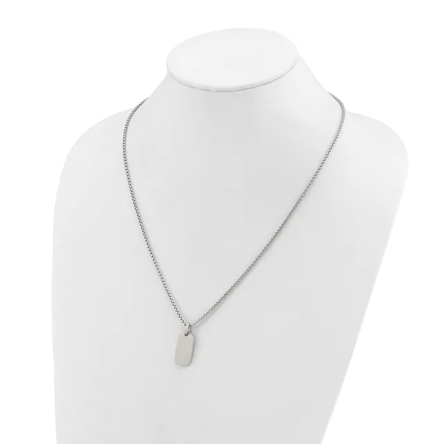 A silver-toned chain necklace with a small rectangular pendant displayed on a white mannequin bust.