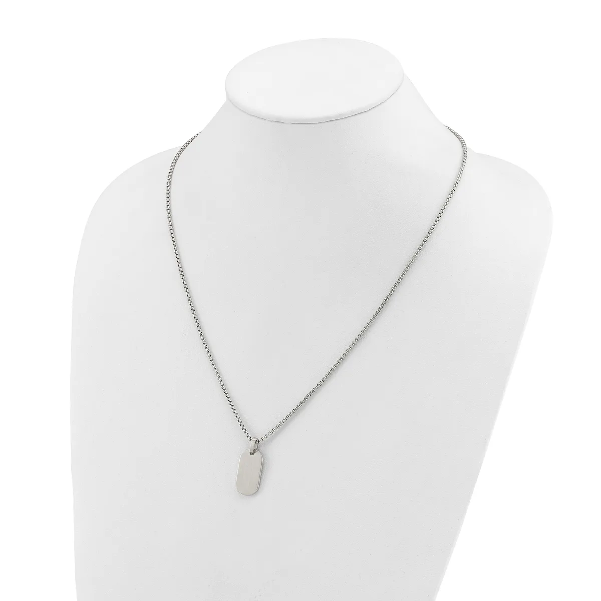 A silver-toned chain necklace with a small rectangular pendant displayed on a white mannequin bust.