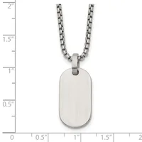 A stainless steel dog tag pendant with brushed finish hangs from a matching chain, shown against a ruler measuring approximately 1 inch wide by 1.75 inches tall.