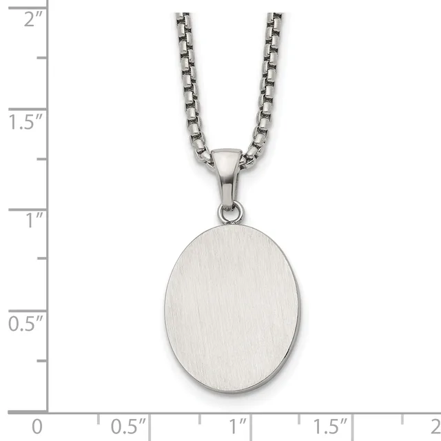 A brushed silver oval pendant hangs from a box chain necklace, displayed against a ruler showing the pendant measures approximately one inch tall.