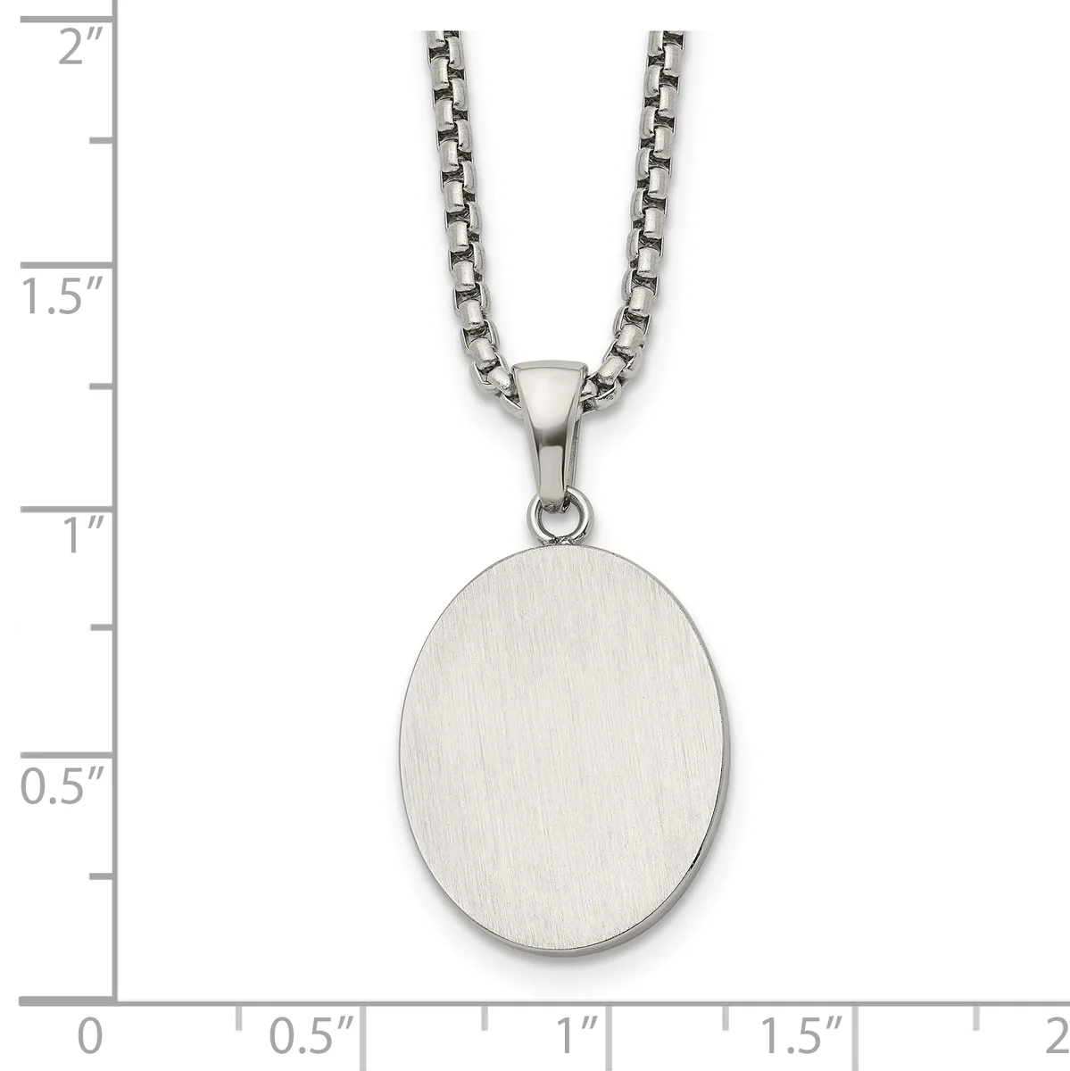 A brushed silver oval pendant hangs from a box chain necklace, displayed against a ruler showing the pendant measures approximately one inch tall.