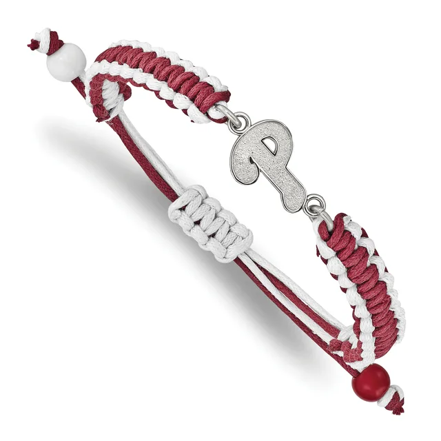 Braided burgundy and white cord bracelet with a silver key charm, white beads at the ends, and small stamped hallmark, displayed on white background.