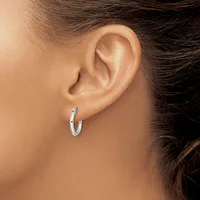 A woman wearing a small silver hoop earring in her earlobe, shown in profile against her neck and shoulder.