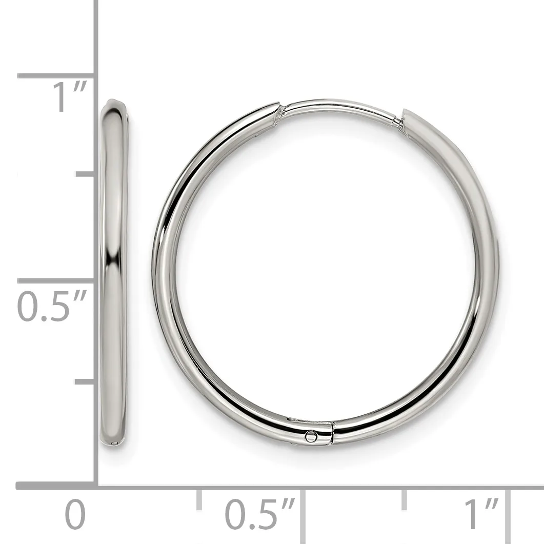 A pair of polished silver-toned hinged bangle bracelets displayed next to a ruler showing approximately one inch in diameter.