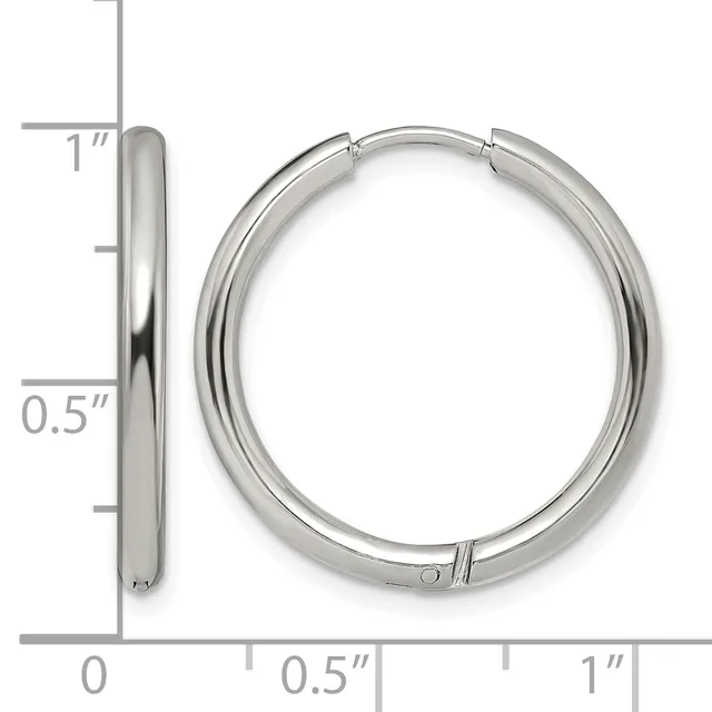 A pair of polished silver-toned hoop earrings with a hinged closure, shown next to a ruler indicating they measure approximately one inch in diameter.
