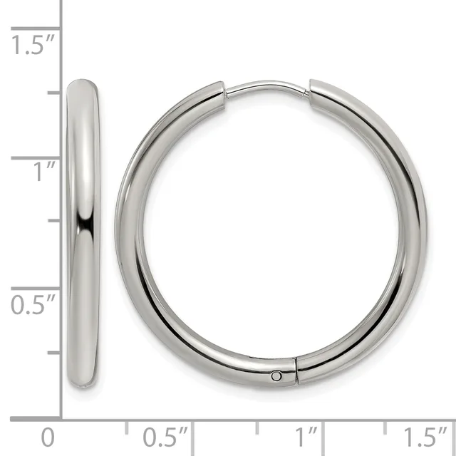 A pair of polished silver-toned hoop earrings displayed next to a ruler showing their dimensions of approximately 1.25 inches in diameter.