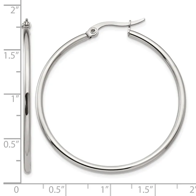 A pair of polished silver-toned hoop earrings with hinged posts, displayed against a measurement scale showing approximately 1.5 inches in diameter.