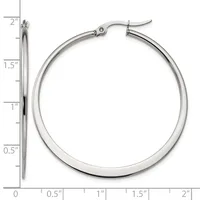 Polished silver-tone hoop earrings with a tube design and hinged posts, displayed next to a ruler showing they measure approximately 1.5 inches in diameter.