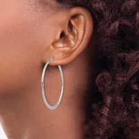 A person wearing a large oval silver hoop earring, shown in profile against their ear and shoulder.
