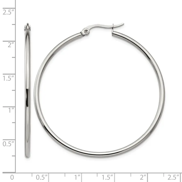 A pair of polished silver-toned hoop earrings displayed next to a ruler showing they measure approximately two inches in diameter.