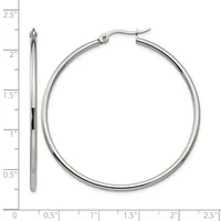 A pair of polished silver-toned hoop earrings displayed next to a ruler showing they measure approximately two inches in diameter.