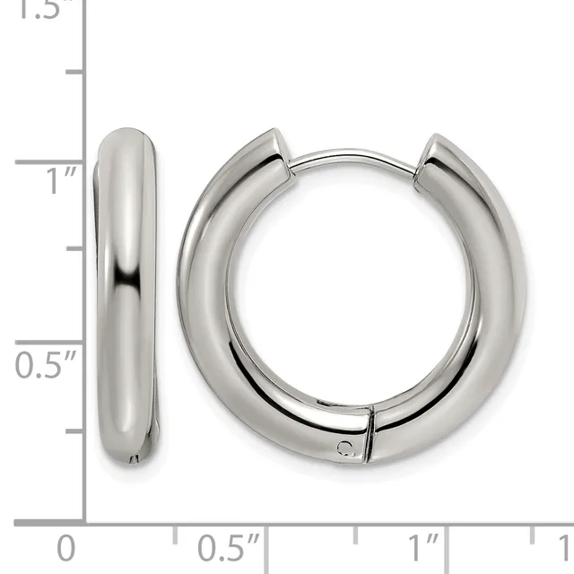 A pair of polished silver-toned chunky hoop earrings with hinged closures, shown next to a ruler for scale indicating approximately one inch in diameter.