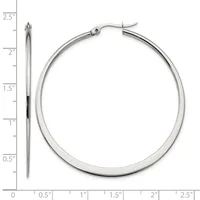 A pair of polished silver-toned hoop earrings displayed next to a ruler showing they measure approximately 2.5 inches in diameter.