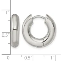 A pair of polished silver huggie hoop earrings shown from front and side views with a measurement scale indicating approximately one inch in diameter and half inch in width.
