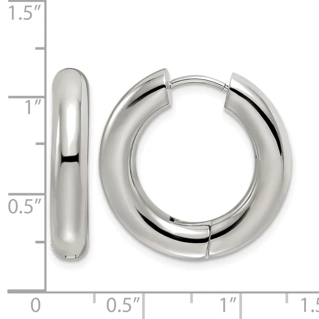 A pair of polished silver-toned chunky hoop earrings displayed against a measurement scale showing they are approximately one inch in diameter.