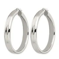 A pair of polished silver-tone hoop earrings with a smooth, curved surface and hinged closure posts, displayed side by side.
