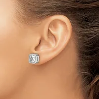 A person wearing a silver stud earring with a square white gemstone set in a bezel setting, shown on their earlobe from a side view.