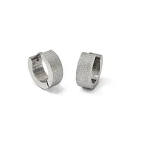 A pair of textured silver huggie hoop earrings with a frosted finish shown from two angles against a white background.