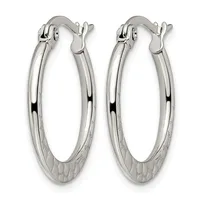 A pair of polished silver oval hoop earrings with textured bases and hinged closures, displayed against a white background.