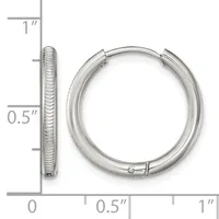 A pair of textured silver hoop earrings with a measurement scale showing they are approximately one inch in diameter.