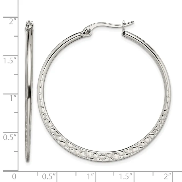 A pair of silver-toned hoop earrings with a textured diamond-cut surface, shown from front and side views next to a measurement ruler indicating they are approximately 1.5 inches in diameter.