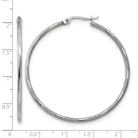 A pair of silver twisted hoop earrings with hinged closures, shown next to a ruler measuring approximately two inches in diameter.