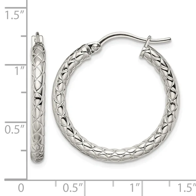 A pair of silver hoop earrings with a textured crosshatch pattern, measuring approximately 1.25 inches in diameter, displayed against a measurement scale.