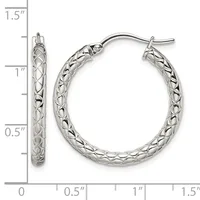 A pair of silver hoop earrings with a textured crosshatch pattern, measuring approximately 1.25 inches in diameter, displayed against a measurement scale.