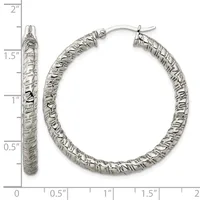A pair of textured silver hoop earrings with a hammered surface finish, displayed against a ruler showing they measure approximately 1.5 inches in diameter.