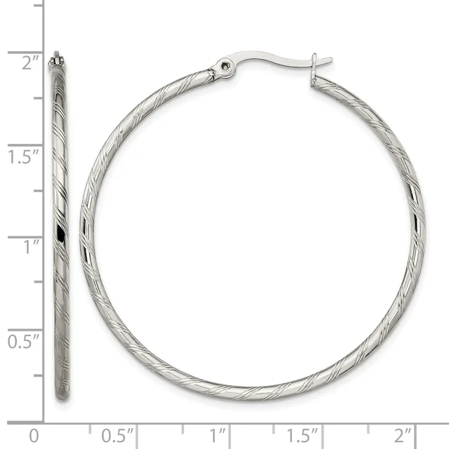 Silver-toned twisted hoop earrings displayed next to a measurement ruler showing approximately two inches in diameter.