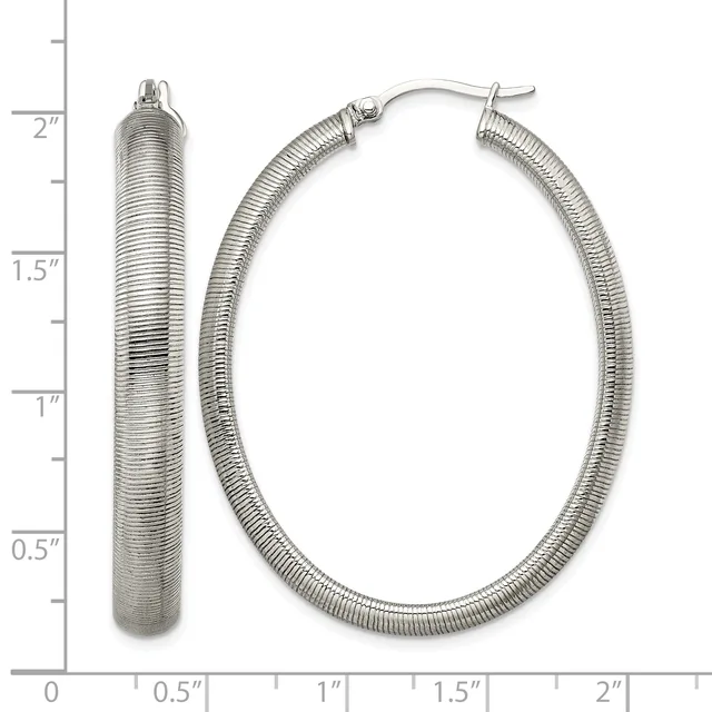 Two silver textured hoop earrings displayed next to a measurement scale, shown from front and side angles with post and clutch closures.