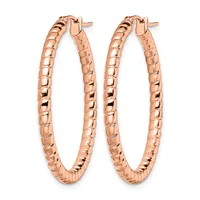 A pair of rose gold hoop earrings with a textured, woven surface pattern, shown against a white background.