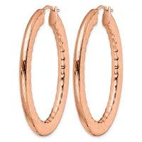 A pair of rose gold hoop earrings with a textured finish and small hallmark, shown from the front against a white background.
