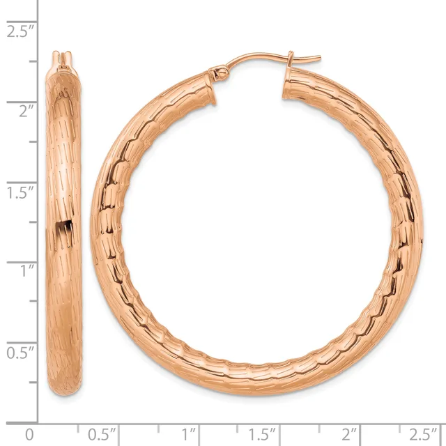 A pair of rose gold hoop earrings with a textured bark finish, shown next to a ruler indicating they measure approximately 2.25 inches in diameter.