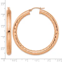 A pair of rose gold hoop earrings with a textured bark finish, shown next to a ruler indicating they measure approximately 2.25 inches in diameter.