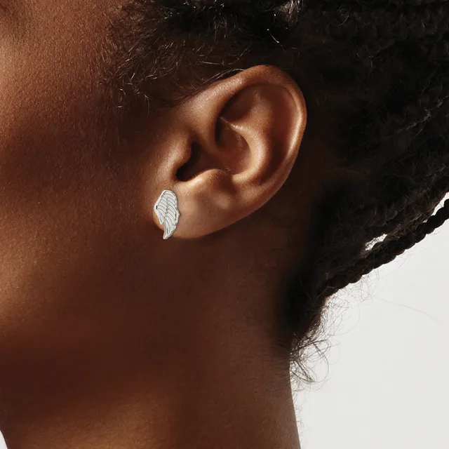 A person wearing a small silver leaf-shaped earring in their earlobe, shown in profile against a white background.