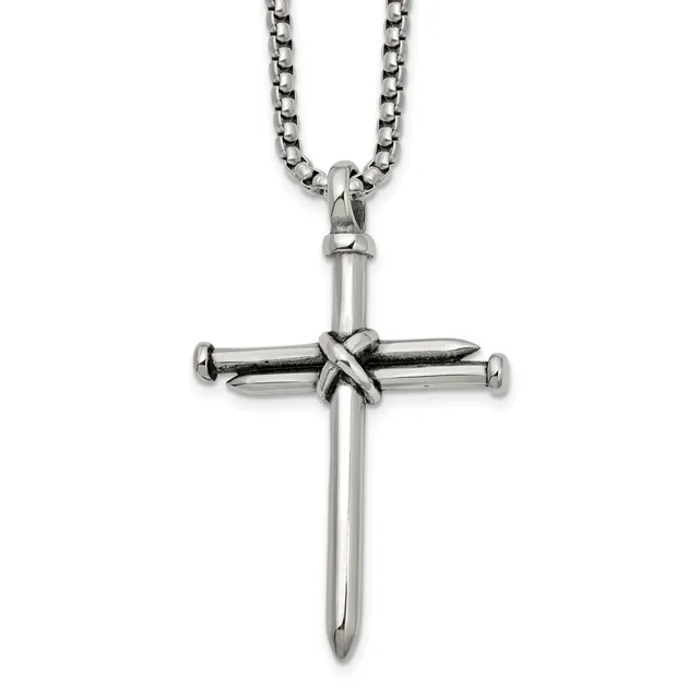 Silver-toned metal cross pendant with nail design at center, suspended from a rolo chain necklace against a white background.