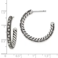A pair of silver hoop earrings with twisted rope texture and beaded edges, displayed next to a measurement scale showing approximately one inch in diameter.